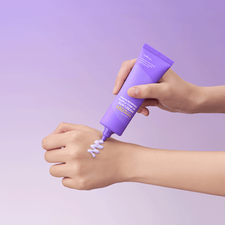 Main appliquant le gel Isntree Onion Newpair en zigzag sur le dos de la main, fond violet pastel
