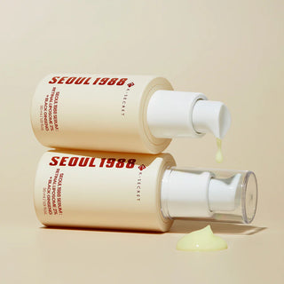 Deux flacons KSECRET Seoul 1988 Serum empiles avec goutte de texture jaune qui coule de la pompe