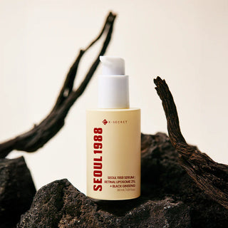 Flacon KSECRET Seoul 1988 Retinal Serum pose sur des roches volcaniques noires et branches sechees