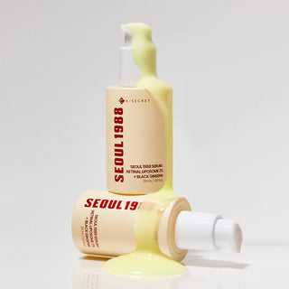 Deux flacons KSECRET Seoul 1988 Retinal Serum recouverts de serum jaune coulant sur fond beige