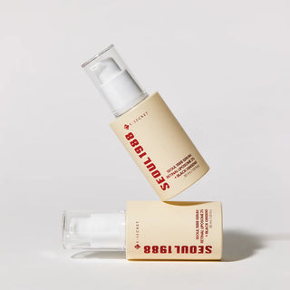 Deux flacons KSECRET Seoul 1988 Retinal Serum en equilibre l'un sur l'autre sur fond gris clair