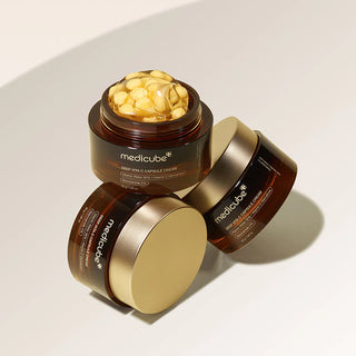 Trois pots Medicube Deep Vita C Capsule Cream, un ouvert avec capsules jaunes et gel transparent