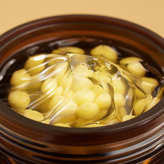 Gros plan capsules vitamine C jaunes dans gel transparent a l'interieur du pot Medicube Deep Vita C