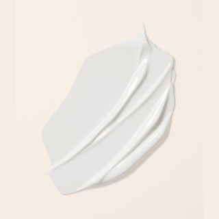 Texture creme blanche epaisse du Boucleme Curl Conditioner etalee sur fond beige clair