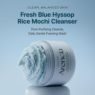Pot ARENCIA Fresh Blue Hyssop Rice Mochi Cleanser incline avec mousse debordante sur fond bleu