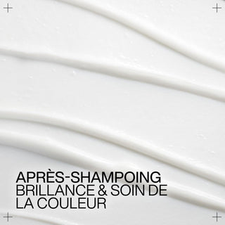 Texture cremeuse blanche du soin Redken Acidic Color Gloss etalee en ondulations