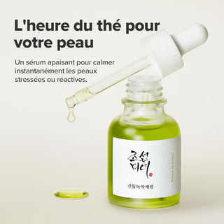 Beauty of Joseon Calming Serum flacon ouvert avec pipette, goutte de serum vert tombe sur fond gris clair