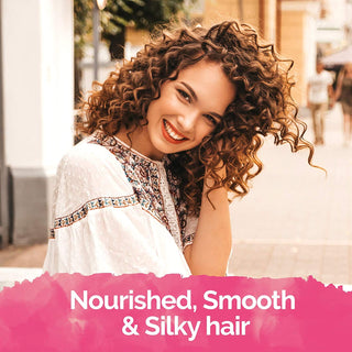 Femme souriante aux boucles brunes, resultat cheveux nourris et soyeux avec Novex Coconut Oil