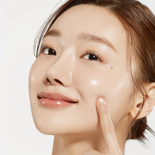 Visage femme appliquant du tonique sur sa joue, peau hydratee et lumineuse apres soin Medicube