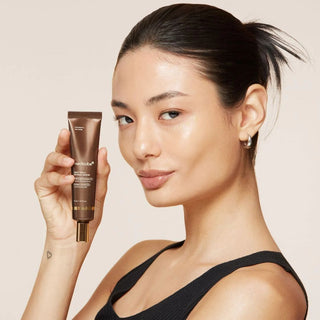 Modele au teint lumineux tenant le tube Medicube Deep Vita A Retinol Serum pres du visage