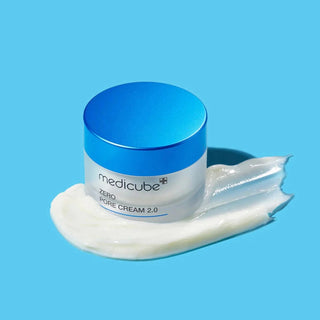 Pot ferme Medicube Zero Pore Cream 2.0 sur fond bleu avec swatch de creme blanche etale