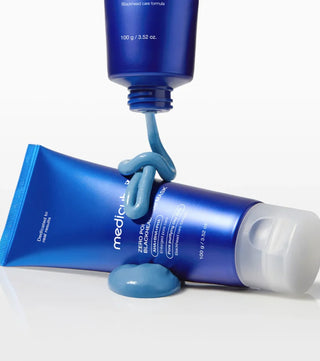 Deux tubes Medicube Zero Pore Mud Mask avec texture argile bleu clair qui coule du bouchon