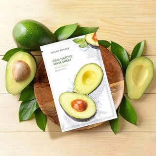 Sachet Nature Republic Avocado pose sur un plateau en bois entoure d'avocats frais et de feuilles vertes