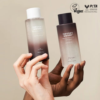 Deux mains tenant les flacons Haruharu Wonder Black Rice Toner classique et peaux sensibles, badges Vegan et PETA