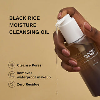 Main tenant le flacon Haruharu Wonder Cleansing Oil avec huile qui coule - nettoie les pores, retire le maquillage