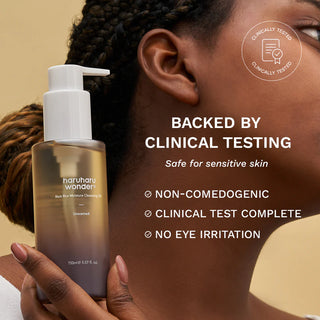 Femme tenant Haruharu Wonder Black Rice Cleansing Oil pres du visage - teste cliniquement, non comedogene, sans irritation