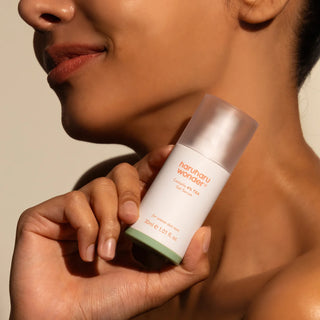 Femme tenant le flacon Haruharu Wonder Centella 4% TXA Gel Serum près du menton et du cou