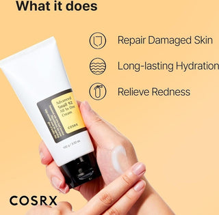 COSRX Snail 92 Cream - main pressant le tube avec creme sur le dos de la main, fond jaune