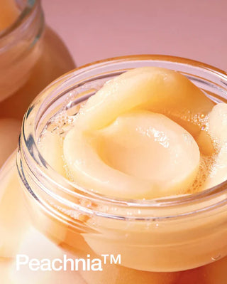 Gros plan extrait de peche Peachnia dans un pot en verre, actif cle de la creme ANUA Peach 77