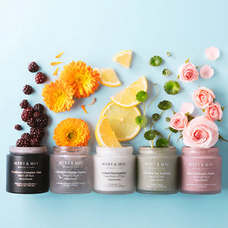 Cinq masques MARY&MAY alignes sur fond bleu ciel avec fruits et fleurs assortis a chaque variante