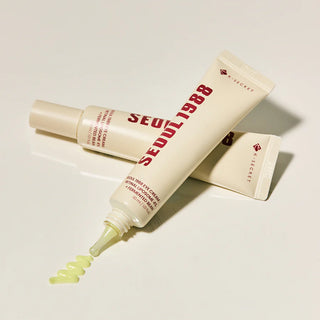 Deux tubes Seoul 1988 Eye Cream K-Secret croises avec texture jaune-vert qui coule de l'embout