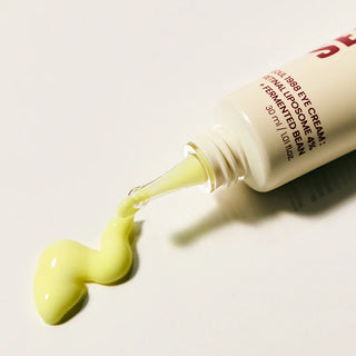 Tube Seoul 1988 Eye Cream K-Secret couche sur le cote, texture jaune-vert coulant sur fond blanc