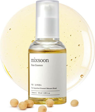 Flacon Mixsoon Bean Essence devant une goutte de texture doree avec graines de soja dispersees