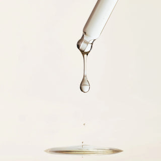 Goutte de serum Beauty of Joseon Glow Deep tombant de la pipette sur fond creme clair