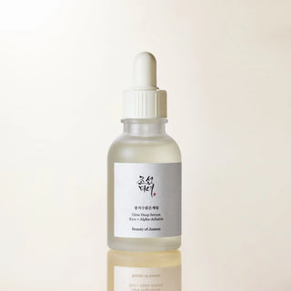 Beauty of Joseon Glow Deep Serum Rice sur fond beige chaud, flacon en verre avec reflet