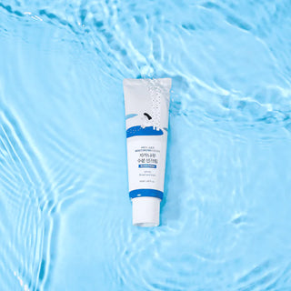 Tube Round Lab Birch Juice Sun Cream immerge dans une eau claire et transparente