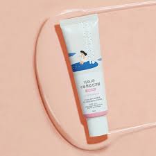 Round Lab Birch Tone-Up Sunscreen pose sur surface transparente rose, format voyage compact 50ml