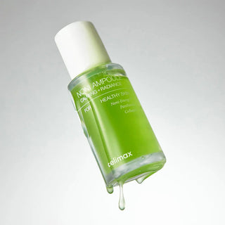 Flacon CELIMAX Noni Ampoule incline avec gouttes de serum vert qui coulent sur fond gris clair