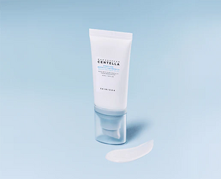 Tube blanc SKIN1004 Hyalu-Cica Sun Serum SPF50+ avec bouchon bleu transparent et touche de texture sur fond bleu clair