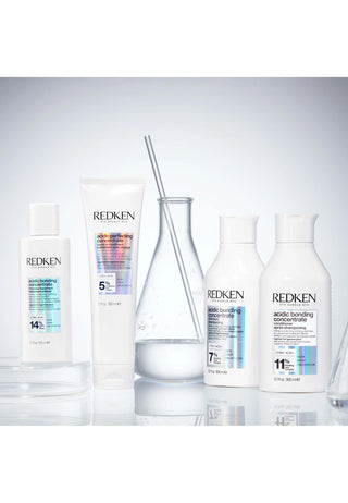 Gamme complete Redken Acidic Bonding Concentrate - quatre produits avec fiole en verre sur fond laboratoire