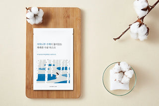 Sachet Round Lab Birch Juice Mask pose sur planche en bois avec branche de coton et tissu