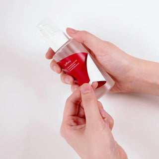 ISNTREE Chestnut AHA 8% Clear Essence - deux mains tenant le flacon pompe sur fond blanc