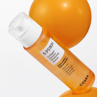 COSRX 5 PDRN Serum incline contre une sphere orange, gros plan sur le flacon pompe
