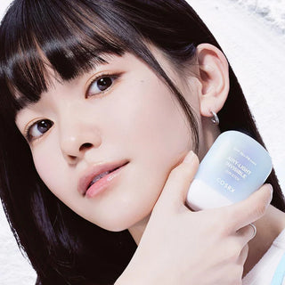Mannequin tenant le COSRX Airy-Light Invisible Sun Stick contre sa joue, peau lumineuse