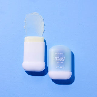 COSRX Airy-Light Sun Stick ouvert avec texture baume translucide sur fond bleu clair