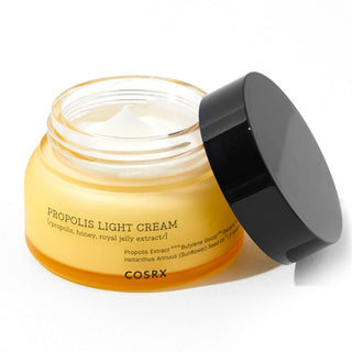 COSRX Propolis Light Cream pot ouvert avec couvercle noir pose a cote, texture creme blanche visible