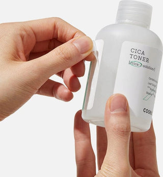Main ouvrant le bouchon du flacon COSRX Cica Toner montrant la texture liquide a travers la bouteille translucide
