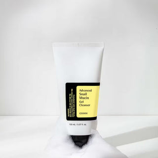 Tube COSRX Advanced Snail Mucin Gel Cleanser blanc avec mousse a la base sur fond clair