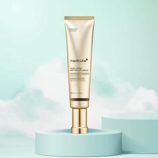 Tube dore MEDICUBE Deep Lifting Peptide Eye Cream sur socle bleu clair et fond nuageux