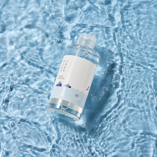 Round Lab 1025 Dokdo Toner - flacon pose dans de l'eau cristalline sur fond bleu, inspiration marine