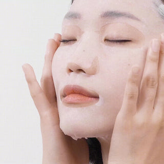 Visage de femme portant le masque en tissu ma:nyo Galac Niacin appliqué sur la peau