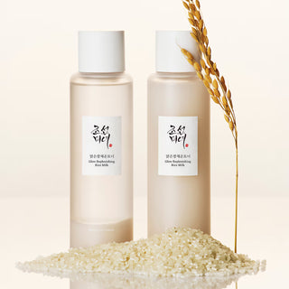 Deux flacons de tonique Beauty of Joseon Glow Replenishing Rice Milk posés sur des grains de riz avec un épi doré