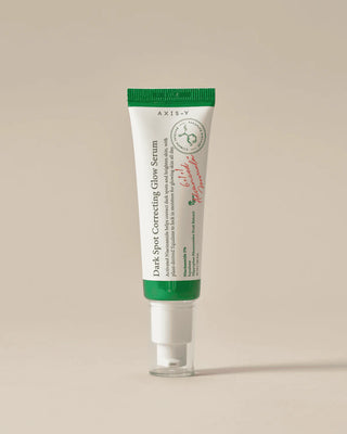 Tube AXIS-Y Dark Spot Correcting Glow Serum debout sur fond beige, etiquette niacinamide 5% visible