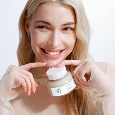 Jeune femme souriante tenant le pot Beauty of Joseon Masque Eclat Riz Fermente et Miel entre ses doigts