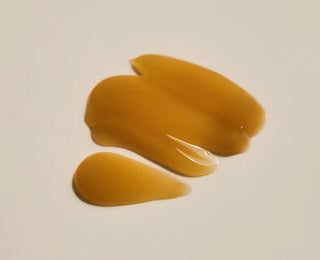 Swatch de texture gel-creme ambre de la SKIN1004 Centella Cream sur fond beige clair