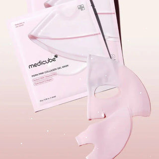 Sachet et masque gel rose Medicube PDRN Pink Collagen flottant sur fond rose avec particules brillantes